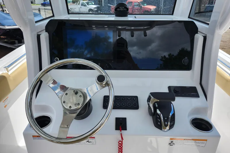 Slide: The Image of 2024 Sportsman Open 232 Center Console dashboard with steering wheel and controls. - 28