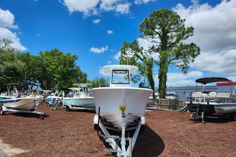 Slide: The Image of 2024 Sportsman Open 232 Center Console boat on display under a clear blue sky. - 3