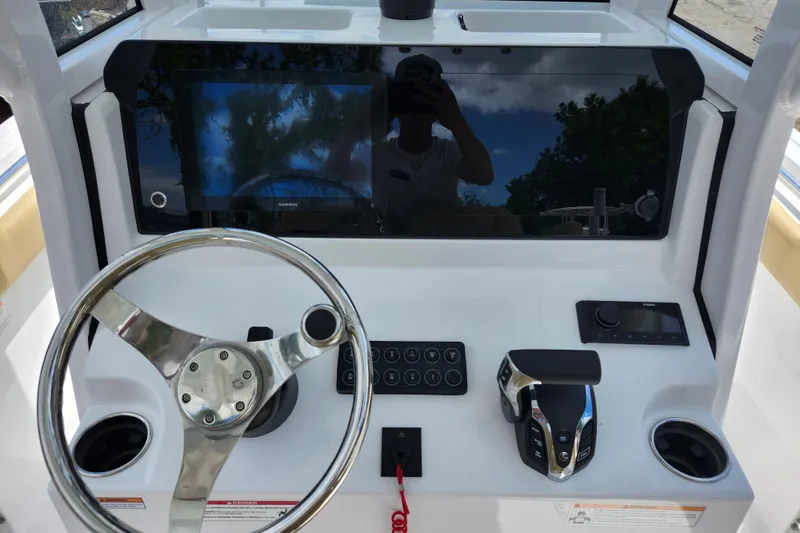 Slide: The Image of 2024 Sportsman Open 232 Center Console dashboard with steering wheel and controls. - 31