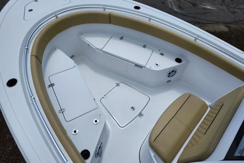 Slide: The Image of 2024 Sportsman Open 232 Center Console boat interior with tan seating and storage compartments. - 50