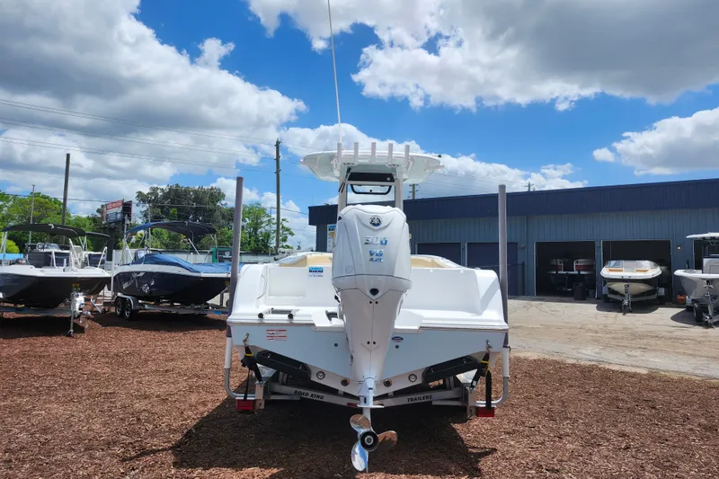 Slide: The Image of 2024 Sportsman Open 232 Center Console boat displayed outdoors under a cloudy sky. - 7