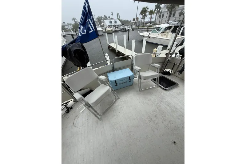 Slide: The Image of 1988 President 35 Double Cabin boat deck with chairs and cooler at marina. - 12