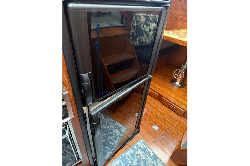 Slide: The Image of 1988 President 35 Double Cabin interior with wooden flooring and modern refrigerator. - 23