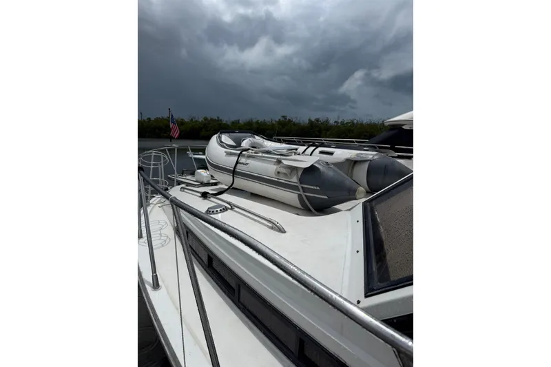 Slide: The Image of 1988 President 35 Double Cabin yacht with inflatable boat on deck under cloudy sky. - 3