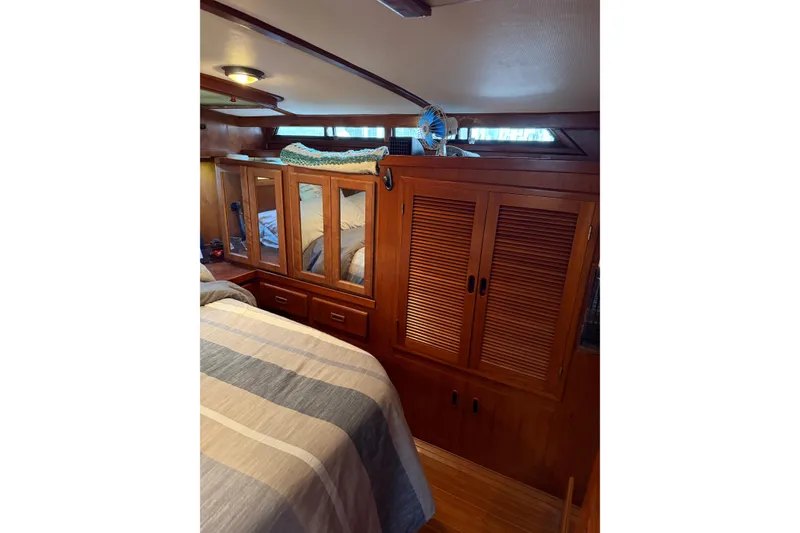 Slide: The Image of 1988 President 35 Double Cabin interior with wooden cabinetry and striped bedding. - 32