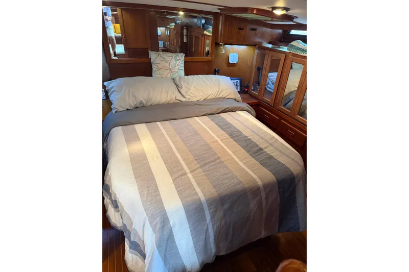 Slide: The Image of Cozy bedroom in 1988 President 35 Double Cabin yacht with striped bedding and wooden cabinetry. - 33
