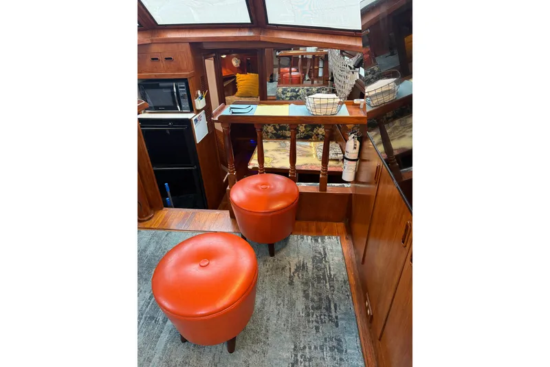 Slide: The Image of Interior of 1988 President 35 Double Cabin yacht with red stools and wooden decor. - 38
