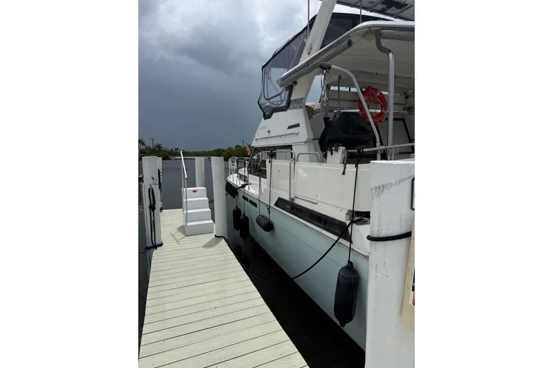 Slide: The Image of 1988 President 35 Double Cabin yacht docked at marina under cloudy sky. - 5