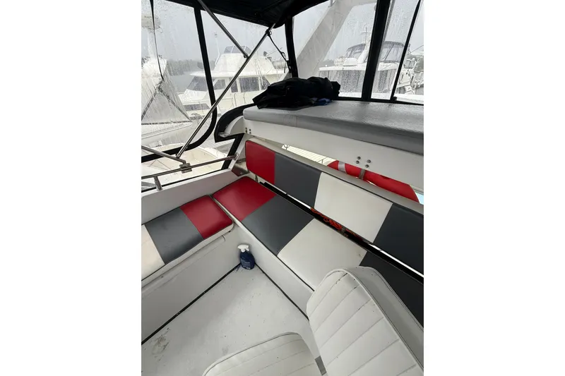 Slide: The Image of 1988 President 35 Double Cabin interior with red and gray seating, docked in marina. - 8