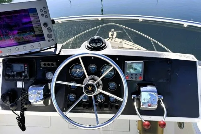 Slide: The Image of Cockpit view of a 1991 Bertram 28 boat with steering wheel and navigation equipment. - 14