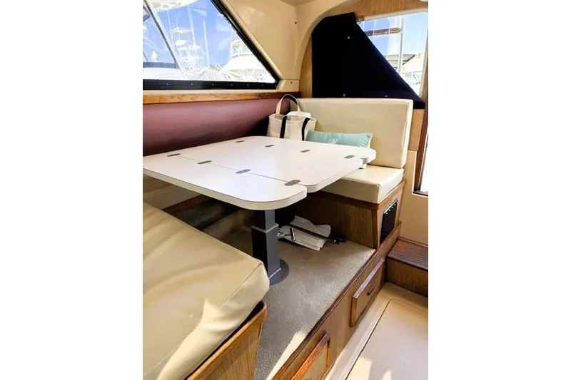 Slide: The Image of Interior of a 1991 Bertram 28 boat with a cozy dining area and window view. - 29