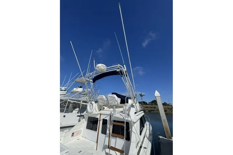 Slide: The Image of 1991 Bertram 28 boat docked under clear blue sky, featuring antennas and radar equipment. - 6