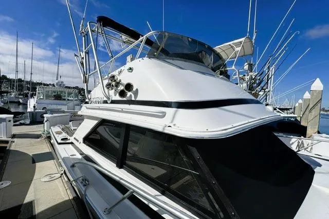 Slide: The Image of 1991 Bertram 28 boat docked at marina under clear blue sky. - 7