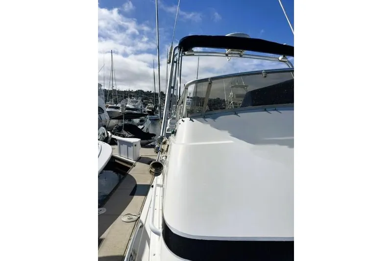 Slide: The Image of 1991 Bertram 28 boat docked at marina under blue sky. - 8