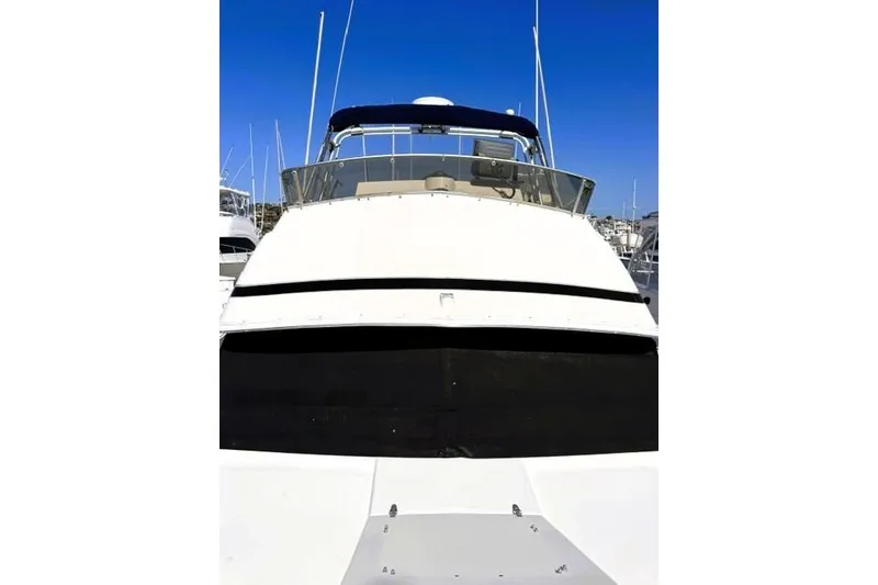 Slide: The Image of 1991 Bertram 28 boat with blue canopy, docked under clear blue sky. - 9