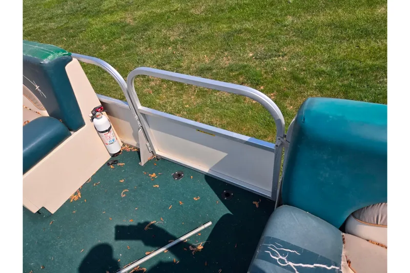 Slide: The Image of 1998 Starcraft boat interior with green seats, fire extinguisher, and metal railing. - 12