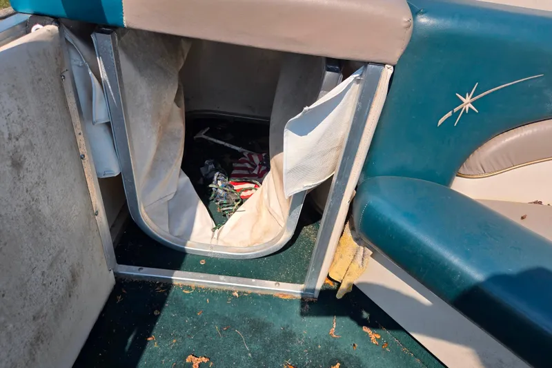 Slide: The Image of 1998 Starcraft boat interior with storage compartment and worn upholstery. - 14