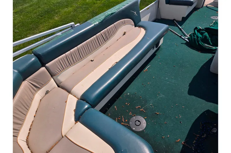 Slide: The Image of 1998 Starcraft boat interior with worn seating and green carpet. - 16