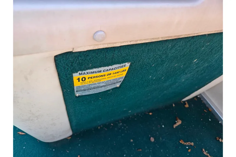 Slide: The Image of 1998 Starcraft boat capacity label, maximum 10 persons or 1440 lbs, on green carpeted surface. - 19