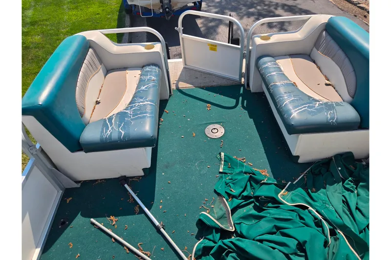 Slide: The Image of 1998 Starcraft boat interior with worn seats and green carpet, scattered debris. - 21