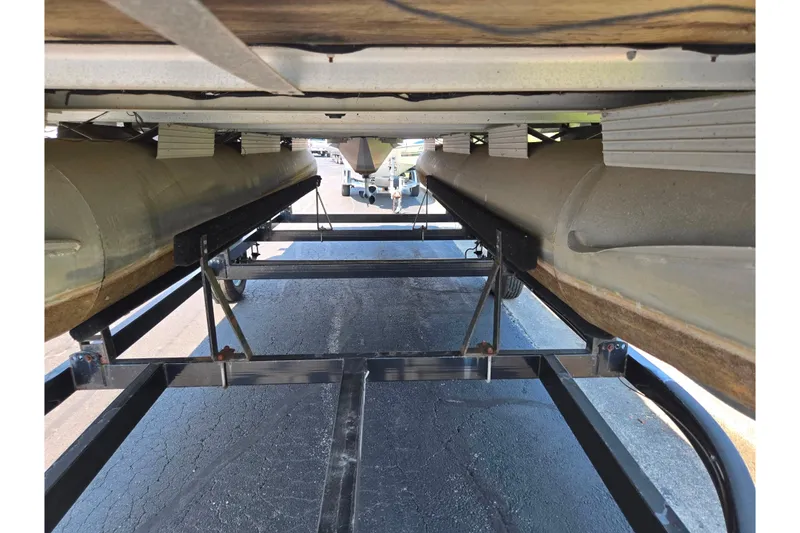 Slide: The Image of Underneath view of a 1998 Starcraft boat on a trailer, showing pontoons and support structure. - 7
