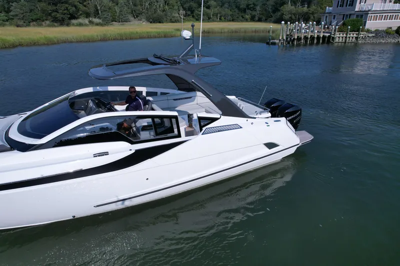 Slide: The Image of 2023 Fairline F//Line 33 Outboard luxury yacht cruising on a serene waterway. - 3