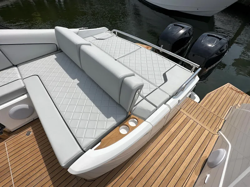 Slide: The Image of 2023 Fairline F//Line 33 Outboard luxury boat with cushioned seating and twin engines. - 6