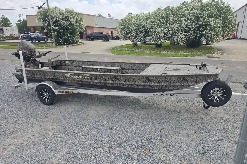 The Image of 2026 Pro-Drive 2060 boat on trailer, camo design, parked outdoors. - 0