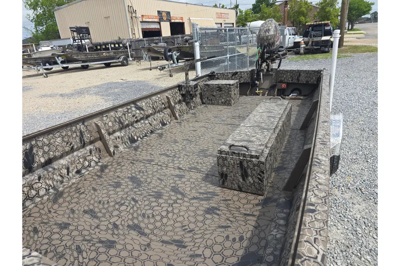 Slide: The Image of Camouflage-patterned Pro-Drive 2060 boat, 2026 model, parked on gravel near industrial buildings. - 10