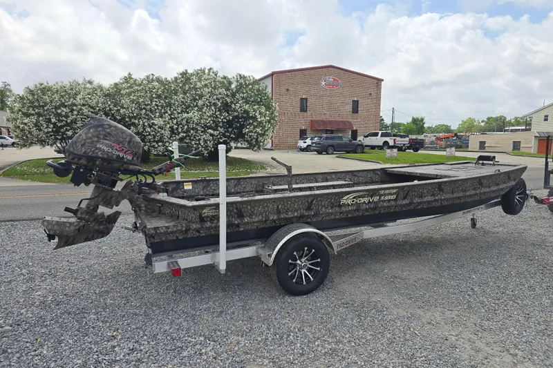 Slide: The Image of 2026 Pro-Drive 2060 boat on trailer, parked outdoors near a brick building. - 4