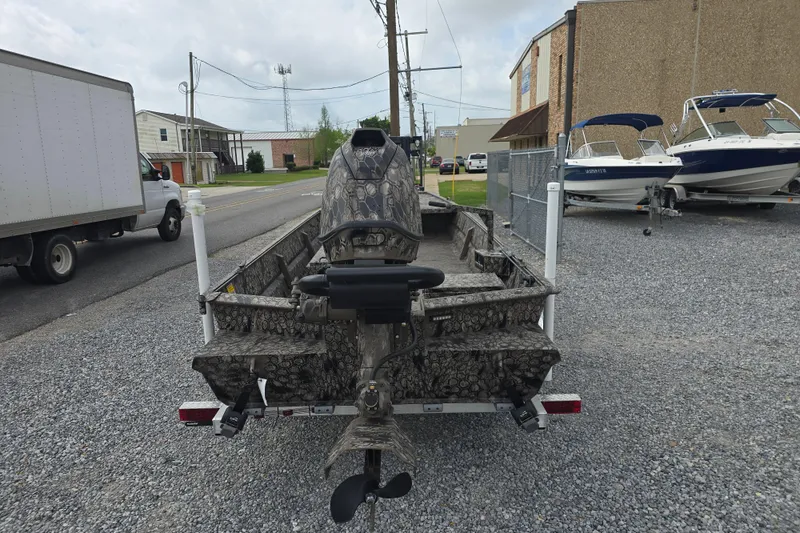 Slide: The Image of Pro-Drive 2060 boat, 2026 model, camo design, parked on gravel near other boats. - 5