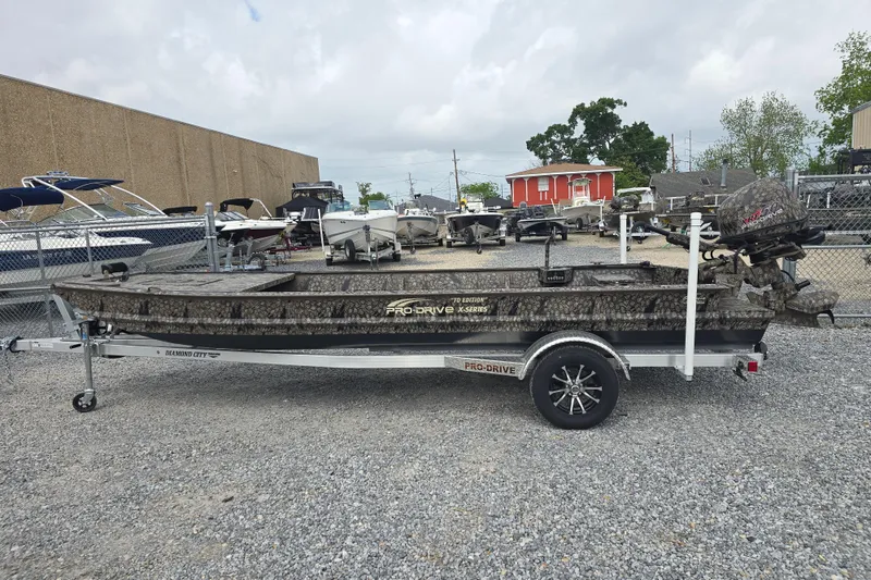 Slide: The Image of 2026 Pro-Drive 2060 boat on trailer, camo design, parked in a boat dealership lot. - 7