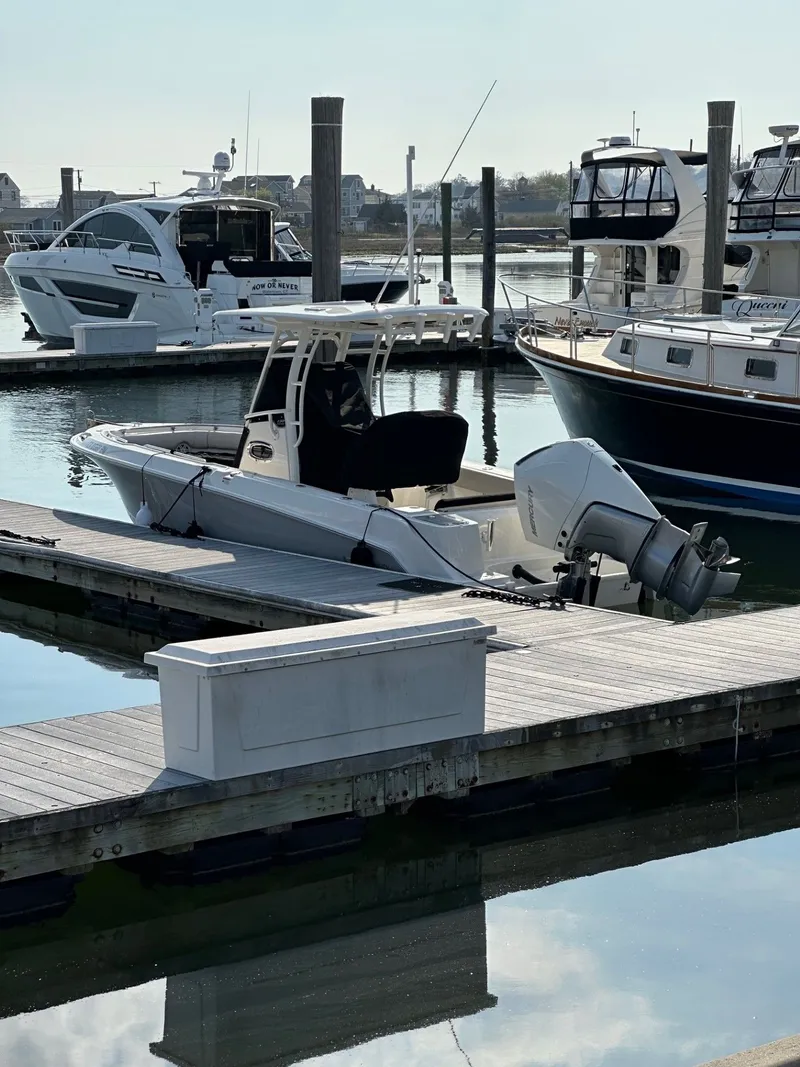 Slide: The Image of 2024 Boston Whaler 230 Outrage boat docked at marina. - 2