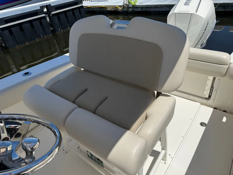 Slide: The Image of Boston Whaler 230 Outrage 2024, beige cushioned seat on boat. - 26