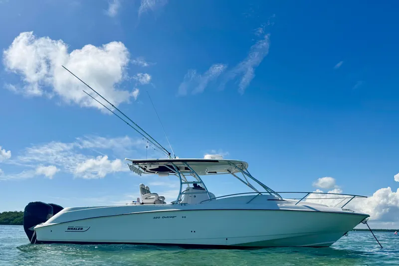 The Image of 2006 Boston Whaler 320 Outrage Cuddy Cabin on clear blue water under sunny sky. - 0