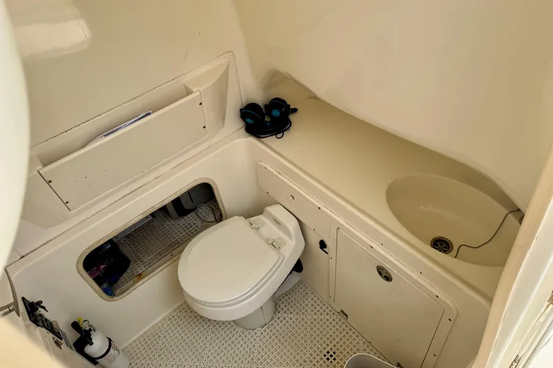 Slide: The Image of 2006 Boston Whaler 320 Outrage Cuddy Cabin interior with beige seating and overhead hatch. - 12