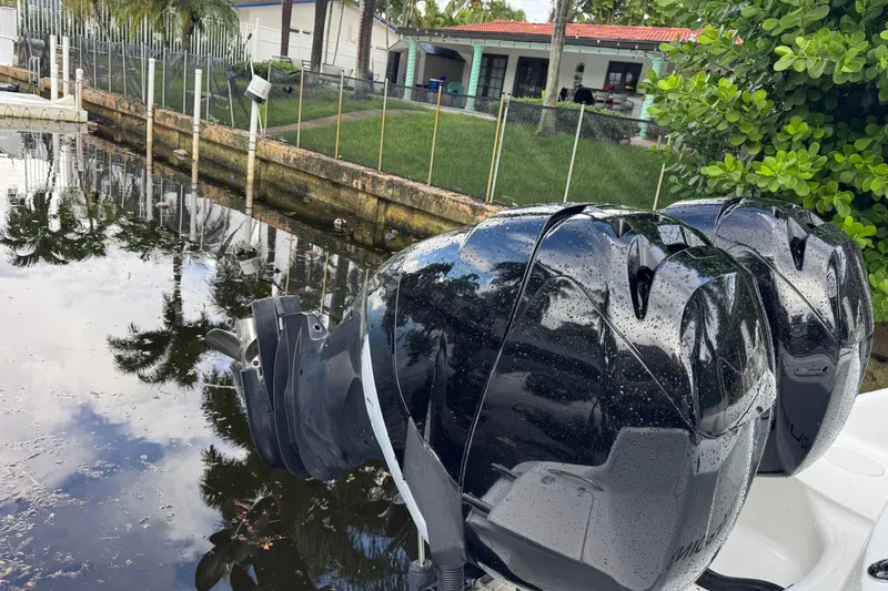 Slide: The Image of 2006 Boston Whaler 320 Outrage Cuddy Cabin boat interior with seating and helm, docked by water. - 17