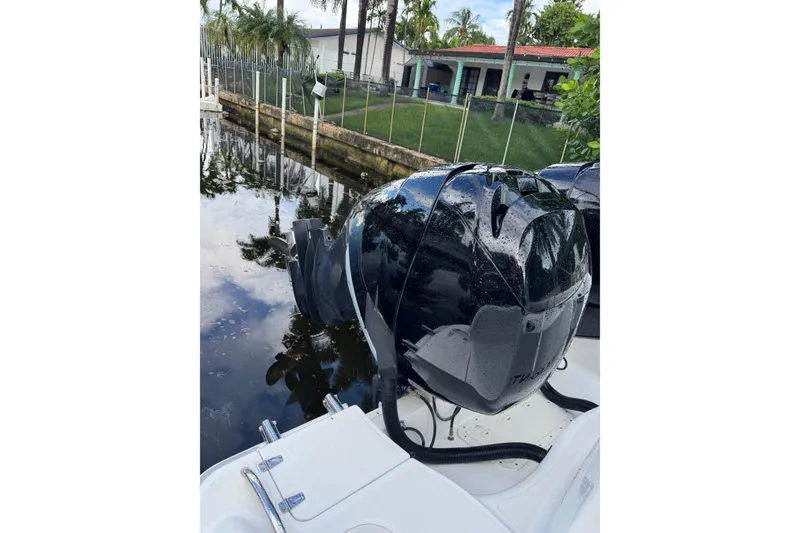 Slide: The Image of 2006 Boston Whaler 320 Outrage Cuddy Cabin interior with helm and seating, docked by water. - 18