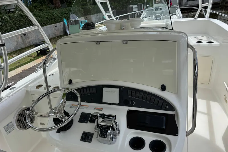 Slide: The Image of 2006 Boston Whaler 320 Outrage Cuddy Cabin interior with seating and storage, docked near palm trees. - 21