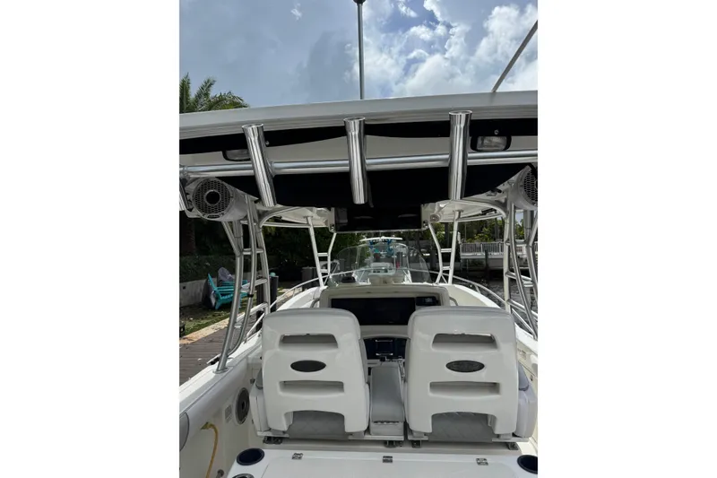 Slide: The Image of 2006 Boston Whaler 320 Outrage Cuddy Cabin with dual engines, docked in a serene canal. - 23