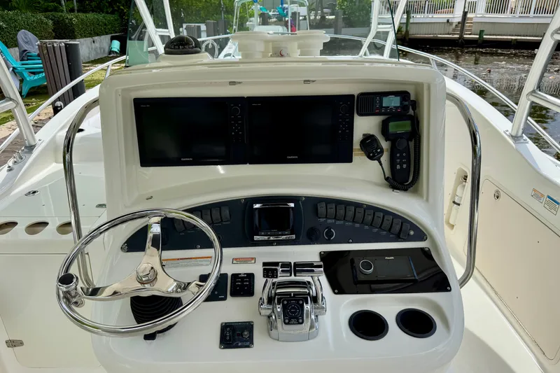 Slide: The Image of 2006 Boston Whaler 320 Outrage Cuddy Cabin with dual engines on a serene waterway. - 24