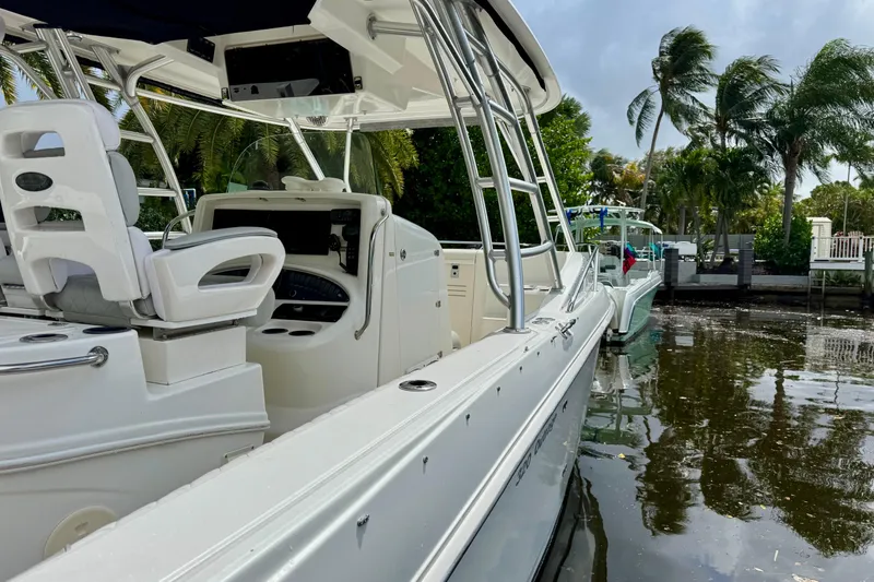 Slide: The Image of Boston Whaler 320 Outrage Cuddy Cabin 2006 with powerful outboard motor in a serene canal setting. - 28
