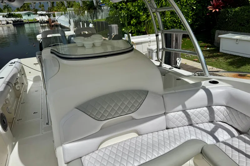 Slide: The Image of 2006 Boston Whaler 320 Outrage Cuddy Cabin docked near lush greenery. - 5