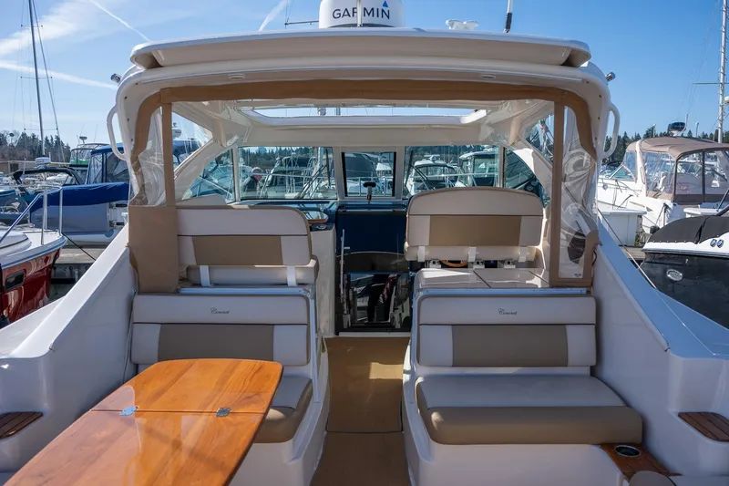 Slide: The Image of 2014 Tiara Yachts 3100 Coronet interior with seating, table, and American flag at marina. - 10