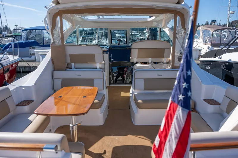 Slide: The Image of 2014 Tiara Yachts 3100 Coronet interior with seating and wooden table. - 12
