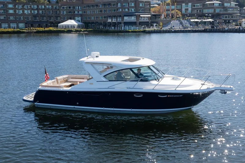 Slide: The Image of 2014 Tiara Yachts 3100 Coronet cruising on calm waters near a marina. - 2