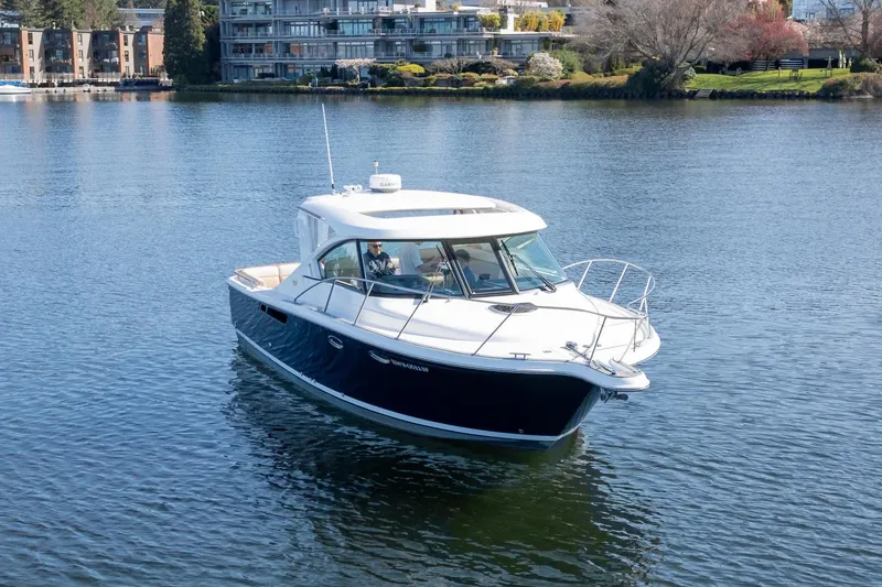 Slide: The Image of 2014 Tiara Yachts 3100 Coronet docked, reflecting on calm water. - 4