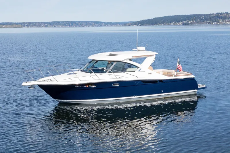 Slide: The Image of 2014 Tiara Yachts 3100 Coronet docked, showcasing sleek blue hull and modern design. - 5