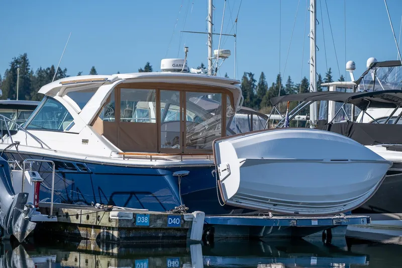 Slide: The Image of 2014 Tiara Yachts 3100 Coronet with attached dinghy on calm water. - 55