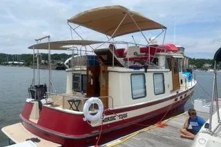 The Image of 1996 Nordic Tug 32 docked, featuring red and white exterior with canopy. - 0